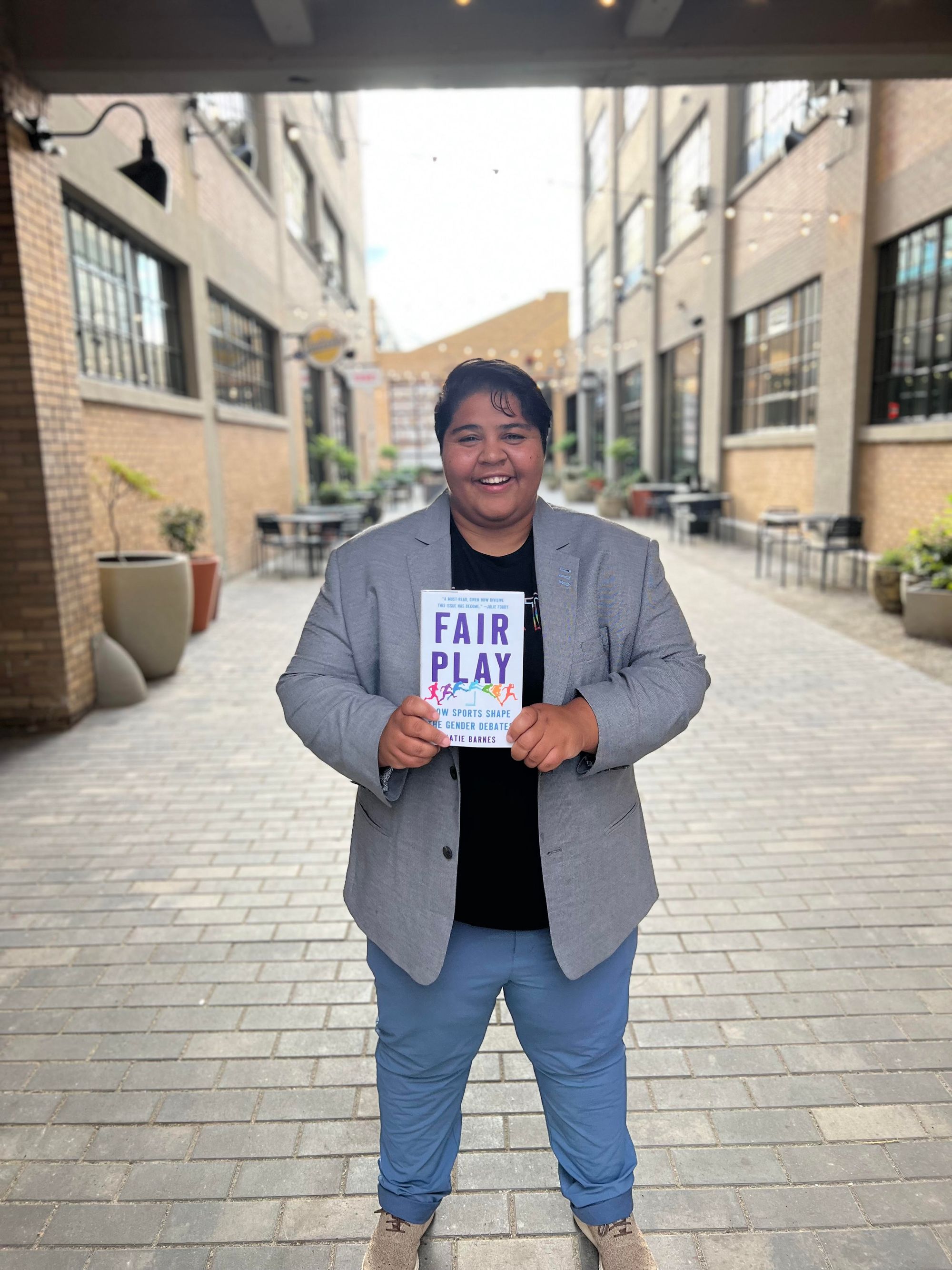 Photo of journalist Katie Barnes holding their book Fair Play